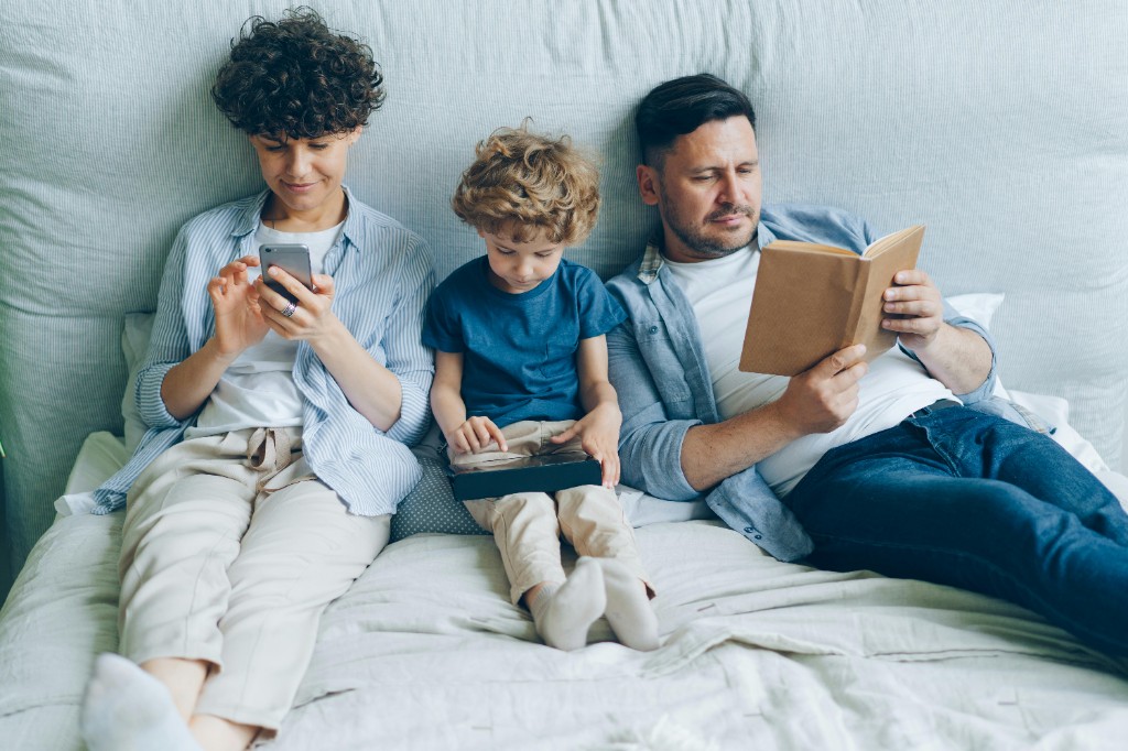 A parent and child talking on a bed