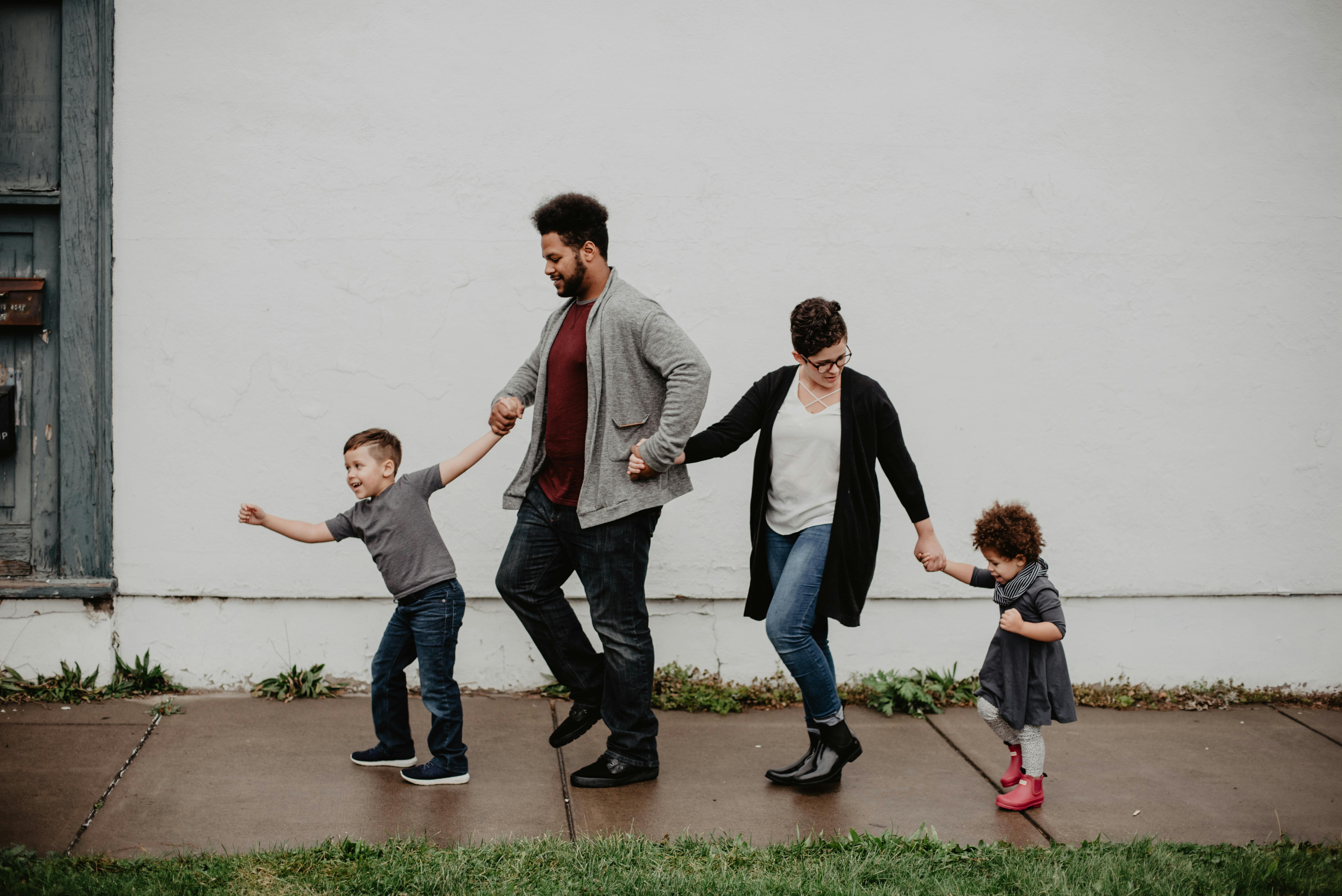 Parents walking hand in hand with their children